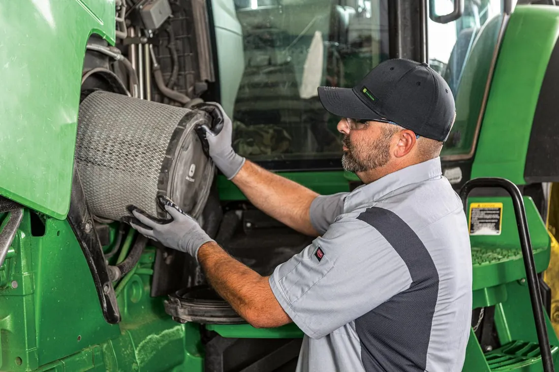 Servicio técnico especializado Técnicos de Compañía Mercantil realizando mantenimiento a maquinaria John Deere